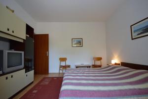 een slaapkamer met een groot bed en een televisie bij Apartment Nela 23 in Pula