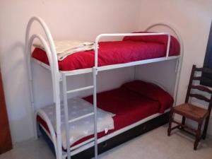 托罗埃利亚-德蒙特格里apartamento el Cortijo Estartit的带椅子的客房内的两张双层床 更多10张照片