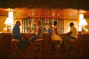 a group of people sitting at a bar at Nosy Saba Private Island & Spa in Nosy Saba