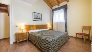 グラードにあるResidence Villa Spiaggiaのベッドと椅子と窓のある寝室