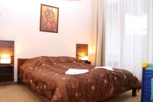 1 dormitorio con 1 cama con manta marrón en Apartamenty Olympic Park, en Kołobrzeg