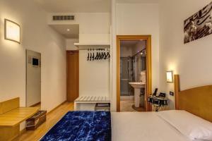 a bedroom with a bed and a bathroom at Hotel Franklin Feel The Sound in Rome