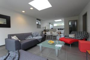 a living room with a couch and a table at Nuvola West in Zottegem