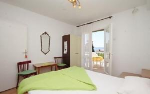 1 dormitorio con cama, mesa y ventana en Villa Elvira, en Gradac