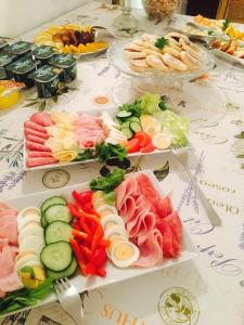 a table filled with different types of food on plates at Dvůr Olšiny -Hotel and Horse-riding in Karviná