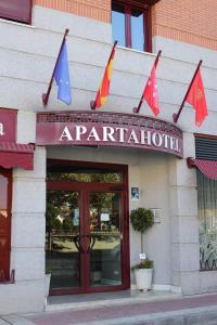 un restaurant avec drapeaux à l'avant d'un bâtiment dans l'établissement Apartahotel Villa de Parla, à Parla