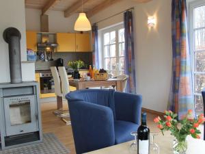 a living room with a blue chair and a stove at Peaceful Holiday Home in Kagsdorf near the Sea in Kägsdorf