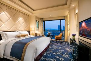 een slaapkamer met een groot bed en een groot raam bij The Pury Hotel in Yiwu