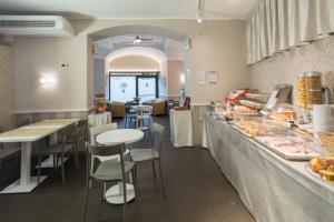 a restaurant with a counter and tables and chairs at Hotel Helvetia in Genoa