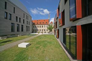a large building with a grassy area in front of it at Ev. Augustinerkloster zu Erfurt in Erfurt