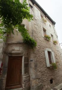 a stone building with a wooden door and windows at La Maison d'Alienor, Gite à Chablis in Chablis