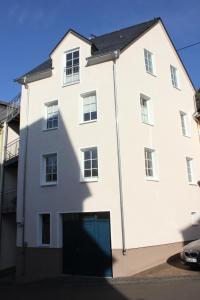 un gran edificio blanco con garaje en Ferienhaus Cuxborn 7, en Zell an der Mosel