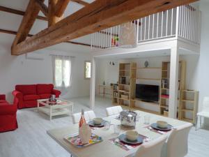 a living room with a table and a red couch at Domaine Les Rivales in Cavaillon