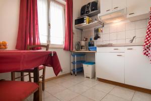 kuchnia z białymi szafkami i czerwoną zasłoną w obiekcie Apartments Nada 354 w Fažanie