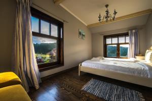 a bedroom with a bed and a large window at The Provence Village in Bukovinka
