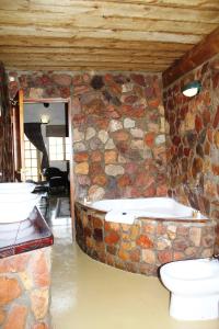 a bathroom with a toilet, sink and tub at Aquila Private Game Reserve & Spa in Touwsrivier