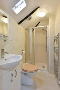 a bathroom with a toilet and a sink and a shower at The Barn @ Bishops Lydeard in Taunton