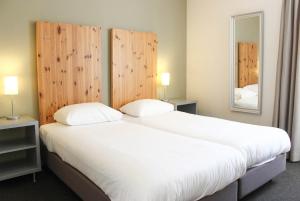 恩斯赫德的住宿－Appartementen Bad Boekelo，卧室配有一张带两个枕头的大白色床