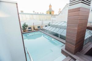 a swimming pool on the roof of a building at One&Lux Byron Suites in Seville