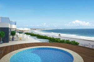 balcone con vista sulla spiaggia di un resort di Apartamento na praia de Armação a Salvador