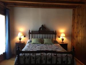 a bedroom with a large bed with two lamps at El Barondillo in Rascafría