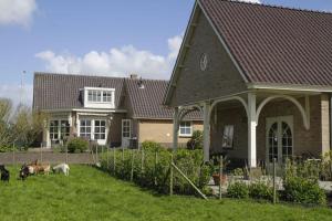 a house with three animals standing in the yard at Het Jaarsveldhof in Montfoort