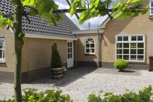 a brick house with a white door at Het Jaarsveldhof in Montfoort