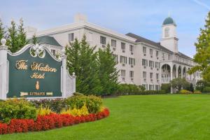 ein großes weißes Gebäude mit einem Schild im Hof in der Unterkunft The Madison Hotel in Morristown