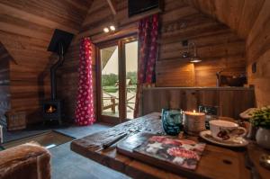 a kitchen with a table with a fireplace in a cabin at Aqualodge Hôtel Insolite in Ermeton-sur-Biert