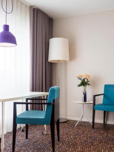 a dining room with a table and two blue chairs at Finn Apartments in Lund