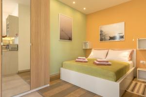 een slaapkamer met een bed met gele muren bij Studio apartment Džapo in Split