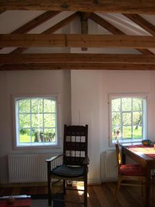 een kamer met 2 ramen en een tafel en een stoel bij Ferienwohnung Sperlingslust in Schleswig