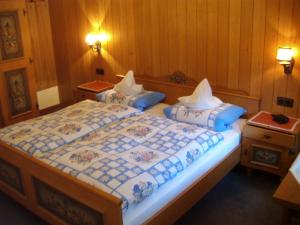 two beds in a room with wooden walls at Pension Haus Seidenweber in Schmallenberg