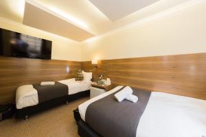 ロンドンにあるチェスター ホテルのベッド2台、薄型テレビが備わるホテルルームです。