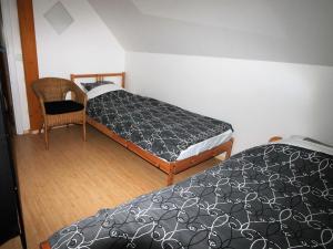 Un dormitorio con 2 camas y una silla. en Snarf, en Jilemnice