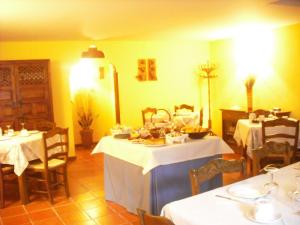 a dining room with two tables with white tablecloths at Casa de Oria in Albarracín