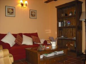 a living room with a red couch and a coffee table at Casa de Oria in Albarracín