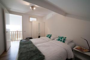 een wit bed in een kamer met een bank bij Appartement de Runsvoort in Helvoirt