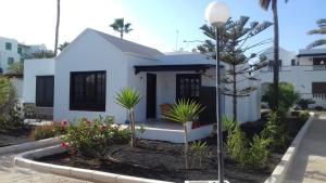 una casa bianca con delle piante davanti di Bastian Nauplius a Costa Teguise