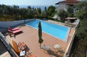 an overhead view of a swimming pool with chairs and an umbrella at Pelagos in Stafylos