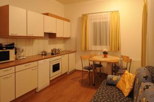 una cocina con armarios blancos y una mesa pequeña con mesa en Apart Handle, en Kappl