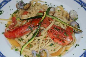a plate of pasta with shrimp and vegetables on it at Hotel Ristorante Borgo La Tana in Maratea