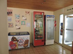 Un refrigerador de Coca Cola al lado de una máquina de refrescos. en Apart Las Lenas, en Las Leñas