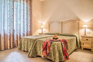 Postel nebo postele na pokoji v ubytování Roccamare Resort - Ville e Appartamenti