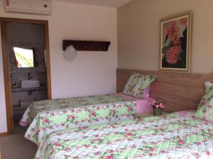 1 dormitorio con 2 camas y una foto en la pared en village na praia do forte en Praia do Forte