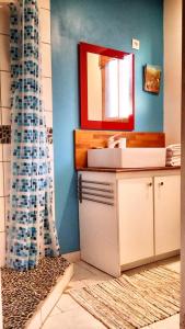 ein Bad mit einem Waschbecken und einem Spiegel in der Unterkunft Residence Deshroses in Deshaies