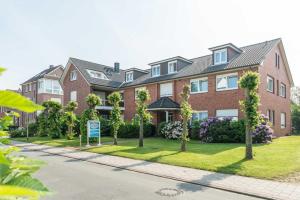 a large brick house with trees in the front yard at Landhaus Braband in Cuxhaven