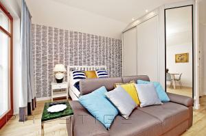 a living room with a couch and a bed at Prestige Apartments Neptun Park in Gdańsk