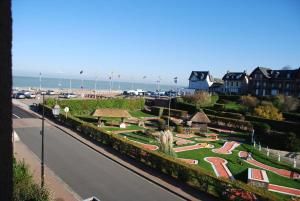 a view of a park next to the beach at Hotel Des Bains in Veulettes-sur-Mer