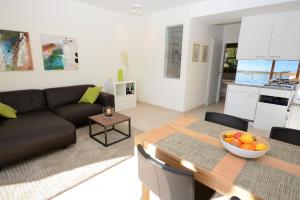 ein Wohnzimmer mit einem Sofa und einem Tisch in der Unterkunft Collina d'Oro in Orselina